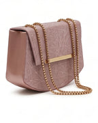 Pink handbag with gold chain strap on a white background