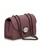 Pink handbag with a cat-shaped charm on a white background