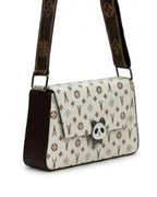 Designer handbag with monogram pattern and panda charm on a white background