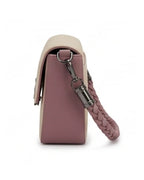 Pink handbag with braided handle on a white background