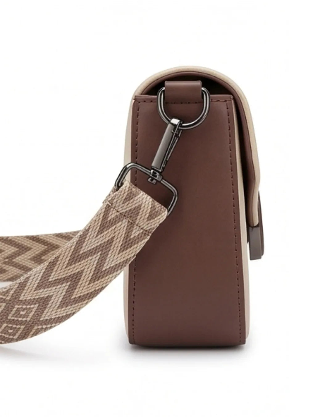 Brown leather bag with a patterned strap on a white background