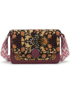 Floral patterned crossbody bag with a colorful strap on a white background