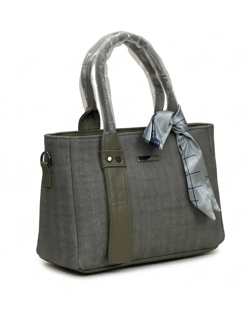 Gray handbag with a green strap and a gray scarf tied around the handle on a white background