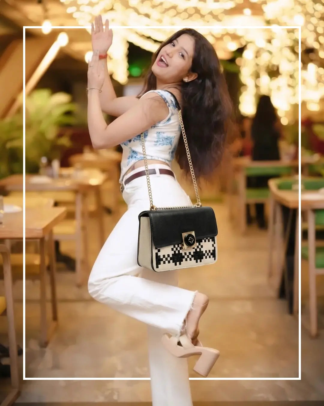 Lora Halle bags Woman posing with a black handbag in an outdoor setting