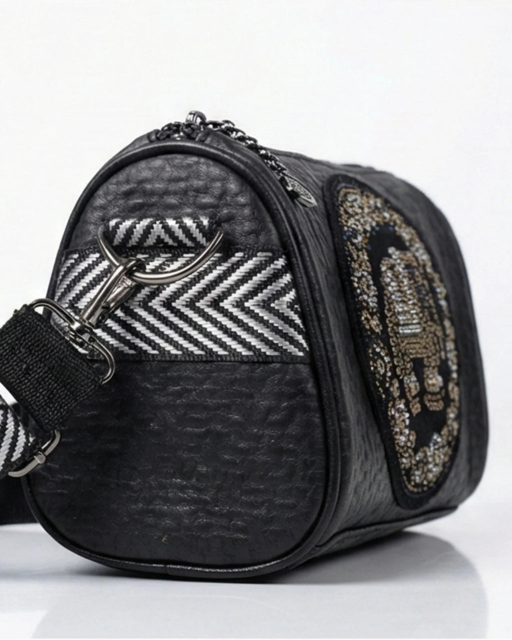 Black handbag with patterned accents on a white background