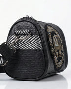 Black handbag with patterned accents on a white background